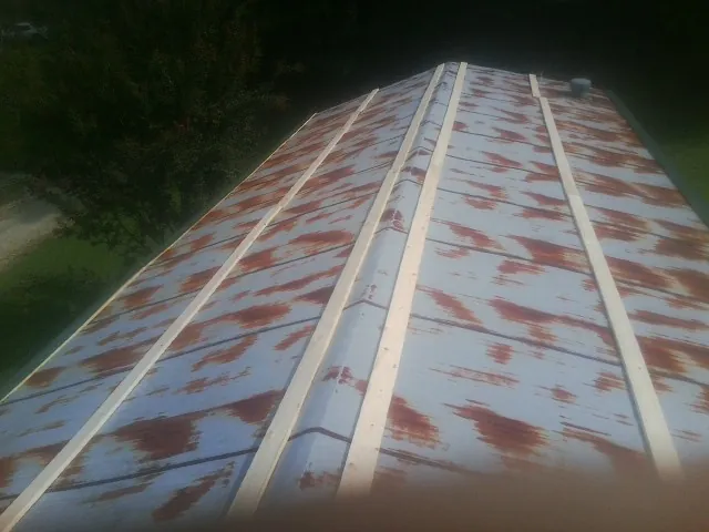 Rusted metal roof panels with new wood purlins before replacement — Storm Damage Roof Repair in Fort Deposit by Roofing Brothers