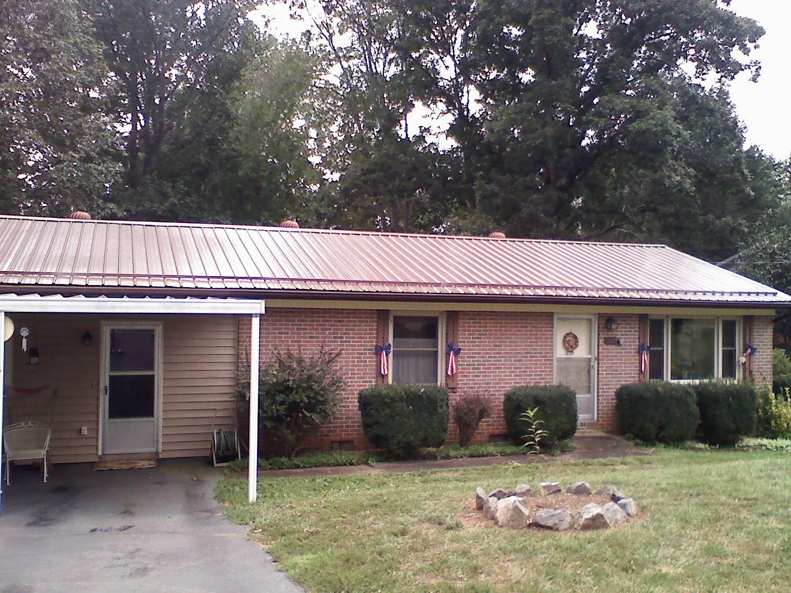Bronze metal roof and carport on a brick ranch home — Roof Repair work by our crew in Fort Deposit