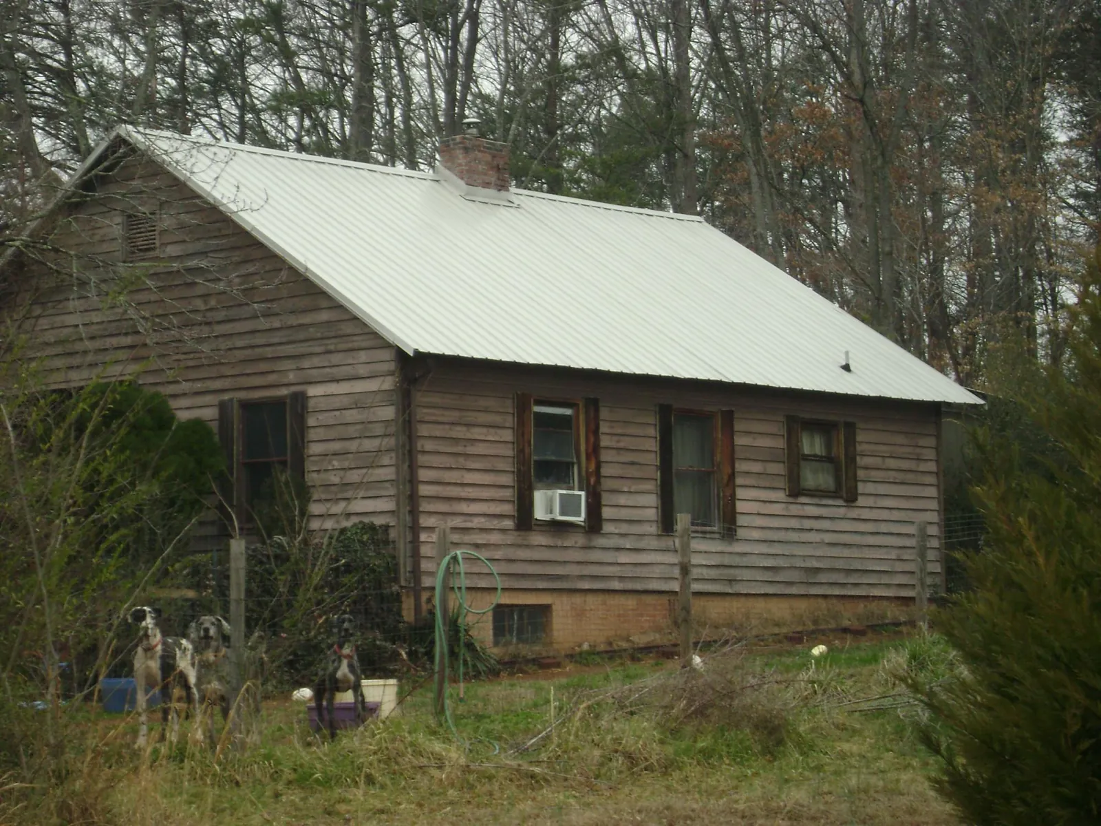 White metal roof on an old wood sided farmhouse, from a Metal Roof Installation job in Fort Deposit